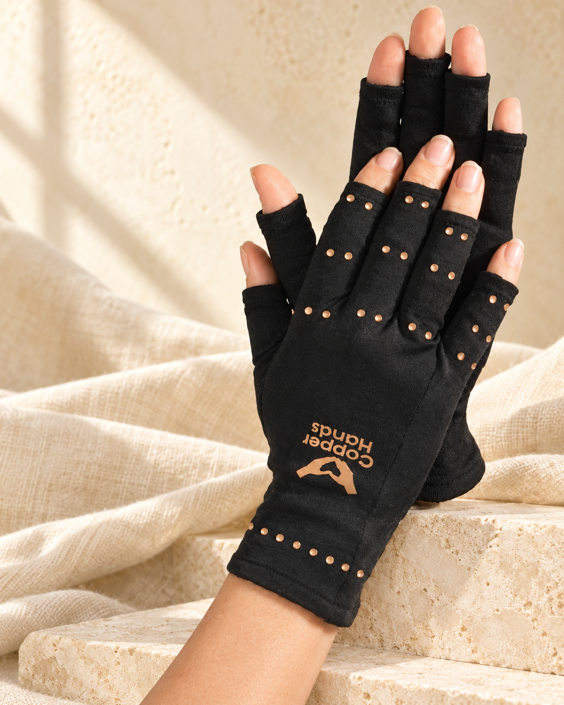 copper compression therapy hand gloves in a warm editorial setting