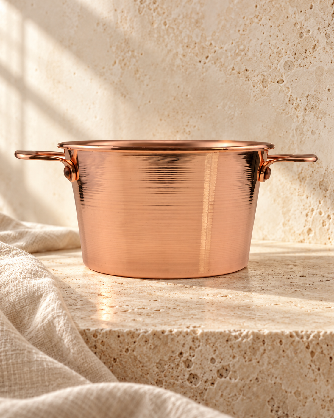 copper pot photographed against ivory stone