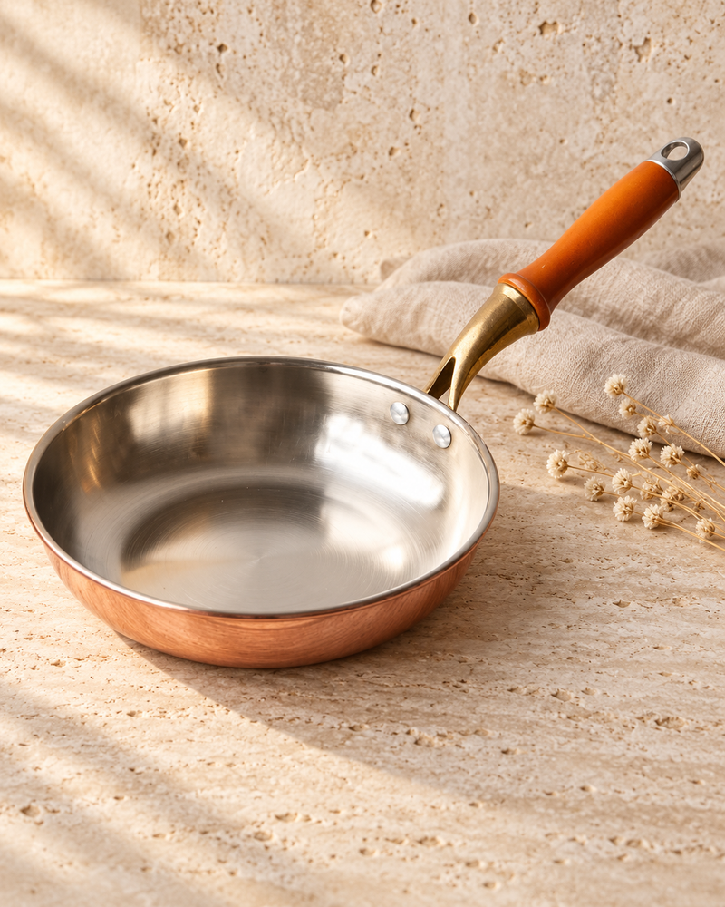 copper wok photographed against ivory stone