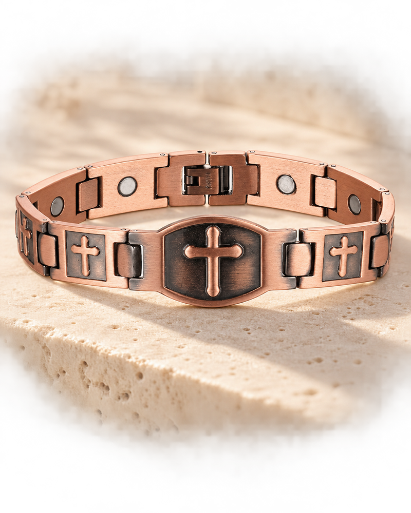 red copper magnetic cross bracelet on a warm stone backdrop